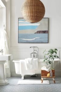 摩洛哥蓝色和白色的瓷砖地板为空间增添了质感。传统的爪形浴缸和水龙头搭配单一的洗手盆，向更传统的感觉致敬。