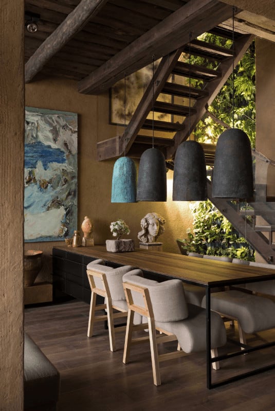 这是一间质朴的亚洲餐厅，由挂在木制餐具上的圆顶吊坠照明，木制餐具上装饰着各种各样的装饰品，还有一面活的绿色墙壁。