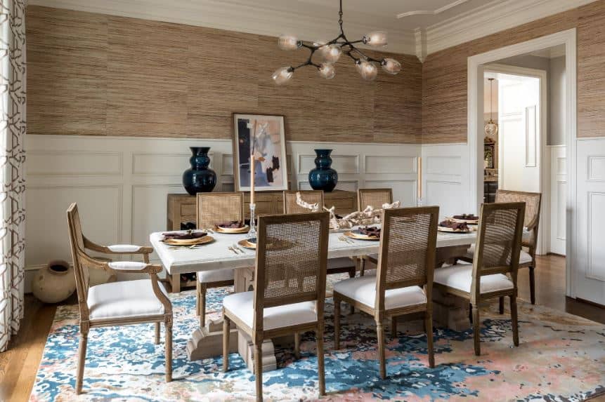 简单的棕色墙壁，棕色椅子和木制餐桌被赋予了一个漂亮的彩色背景，加上美丽的区域地毯和餐厅橱柜上的绘画，在护壁板的衬托下脱颖而出。