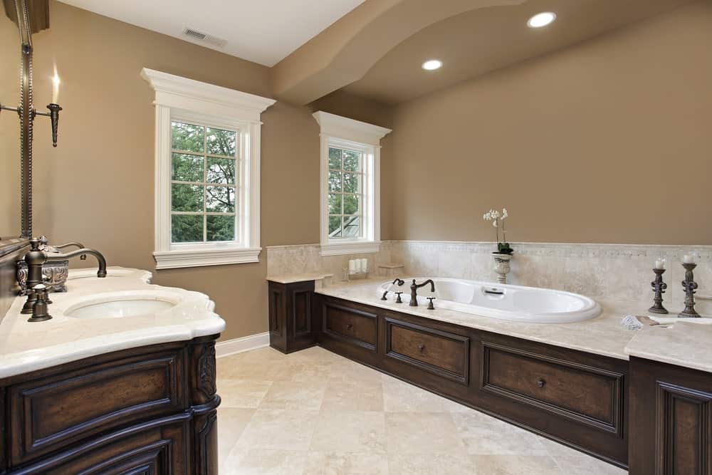 棕色主浴室设有一个双水槽和一个插入式浴缸，看起来绝对优雅。