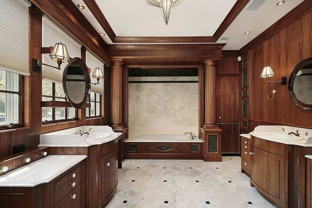 大型棕色主浴室设有时尚的瓷砖地板。房间里有两个水槽柜台和一个落地式浴缸。