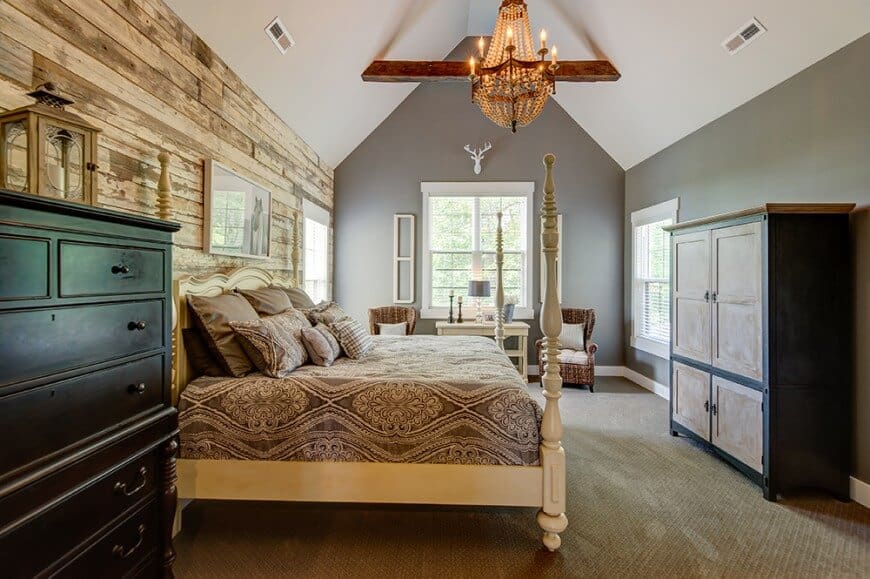 大型乡村风格的主卧室设有质朴的墙壁和地毯地板，以及灰色的墙壁和白色的拱形天花板。该房间设有一张大床和橱柜。