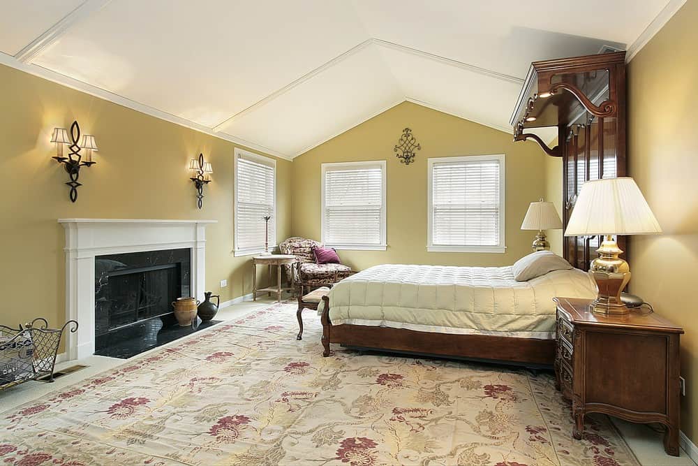 大主卧室设有拱形天花板和一个大的经典区域地毯。它有一张豪华的大床和一个由壁灯照亮的大壁炉。