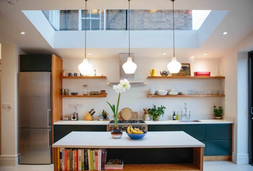 现代厨房，天窗，回收吊坠灯在桦木铺厨房桌子和樱桃单板桦木胶合板端板与绿色无柄抽屉正面。