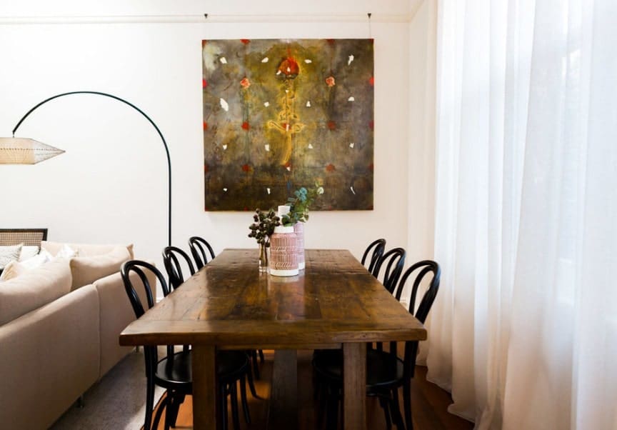 一个集中的镜头在这个小的不拘一格的用餐空间，一个矩形的餐桌和一个非常有吸引力的墙壁装饰。