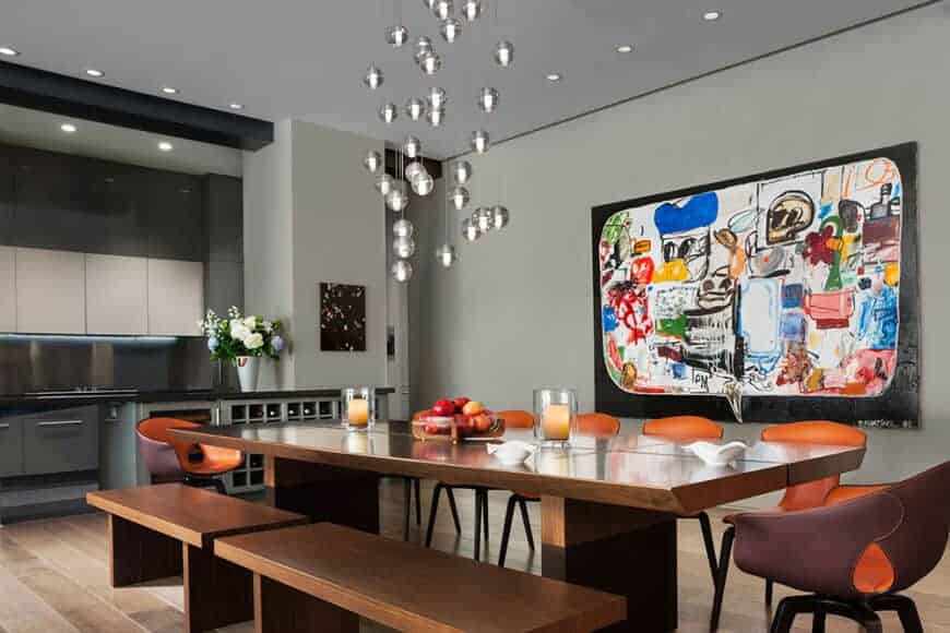 这个非正式的餐厅有一个友好的举止以其丰富多彩的绘画在浅灰色的墙壁和小球形银吊坠灯挂在灰色的天花板。橙色这丰富多彩的计划相匹配的现代餐厅椅子的木桌子和木长椅。