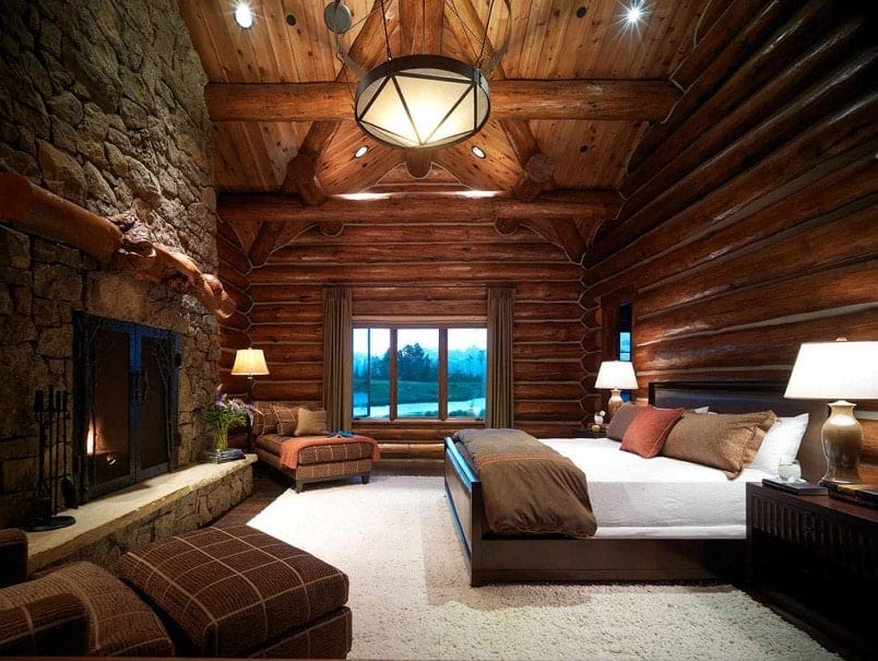 大型主卧室拥有原木墙壁和带有原木梁的天花板。房间里有一张舒适的大床和一个大石制壁炉。