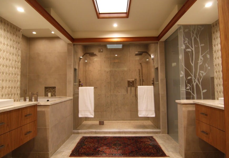 大而优雅的主浴室设有两个水槽柜台，一间带两个淋浴头的步入式淋浴房和一个角落深浴缸。这房间有天窗照明。