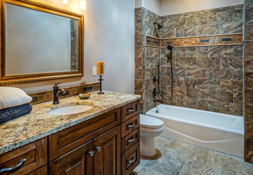 一间外观优雅的主浴室，有一个优雅的水槽柜台，淋浴和浴缸组合。