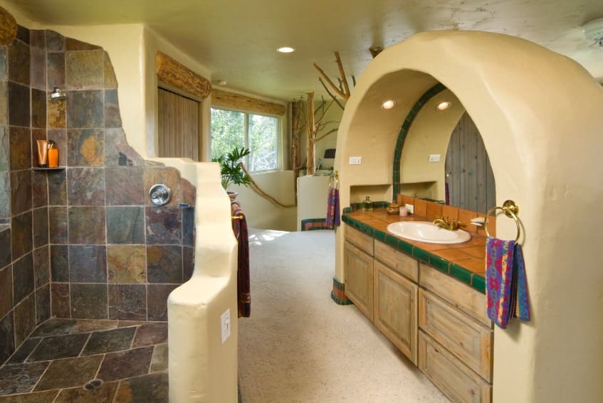 一个美丽而时尚的西南风格的主浴室，一个有趣的步入式淋浴和水槽柜台。