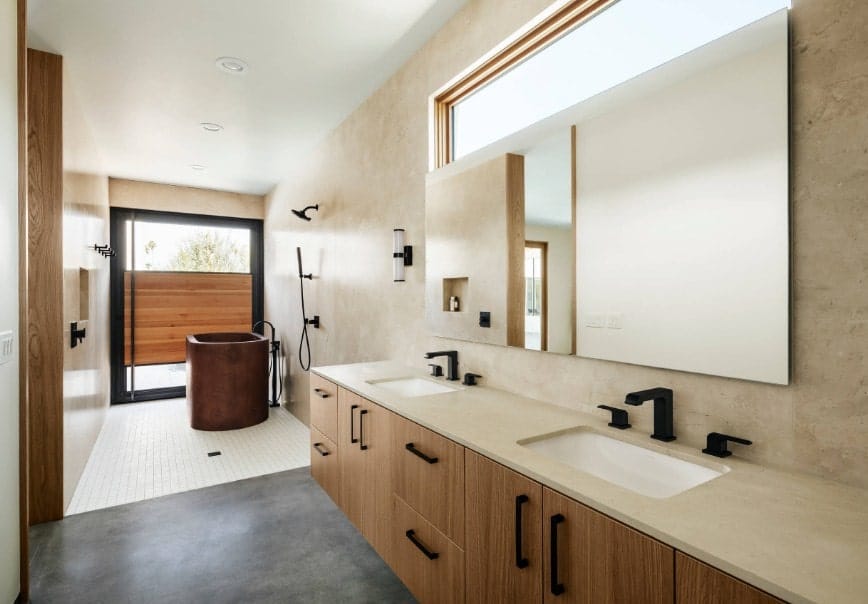 一间明亮的西南风格主浴室，带一个浴缸，靠近开放式淋浴间，还有一个带两个水槽的浮动梳妆台。