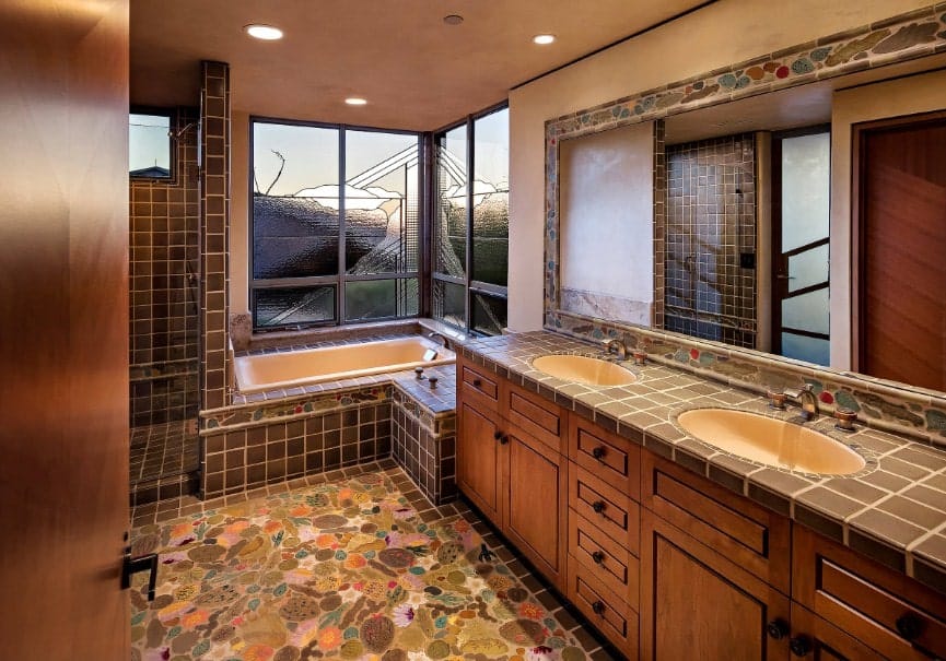 这间主浴室设有高档瓷砖地板。它还设有一个双水槽、一个步入式的角落淋浴间和一个靠近窗户的深泡浴缸。