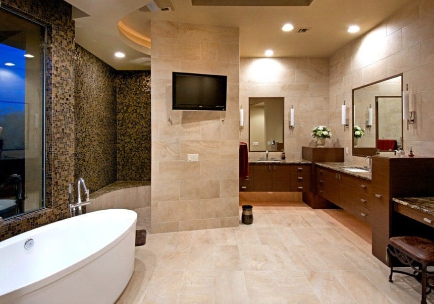 宽敞的主浴室设有独立浴缸，时尚的步入式淋浴间，带微型瓷砖墙和墙上的电视。