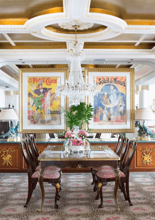 华丽的餐厅设计有大型墙壁艺术安装在镜子墙上和一个时尚的圆形托盘天花板与悬挂水晶吊灯。