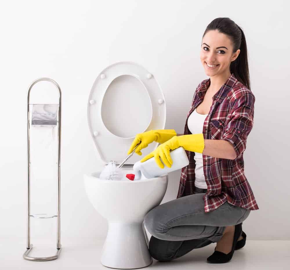 微笑的女人正在打扫厕所。