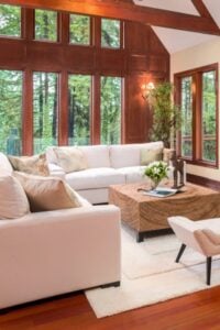 这个宽敞的客厅和传统设计有丰富的木材成型和匹配的木地板。棕色和白色的配色方案。匹配白色沙发和白色三层长毛绒地毯真的流行木地板。