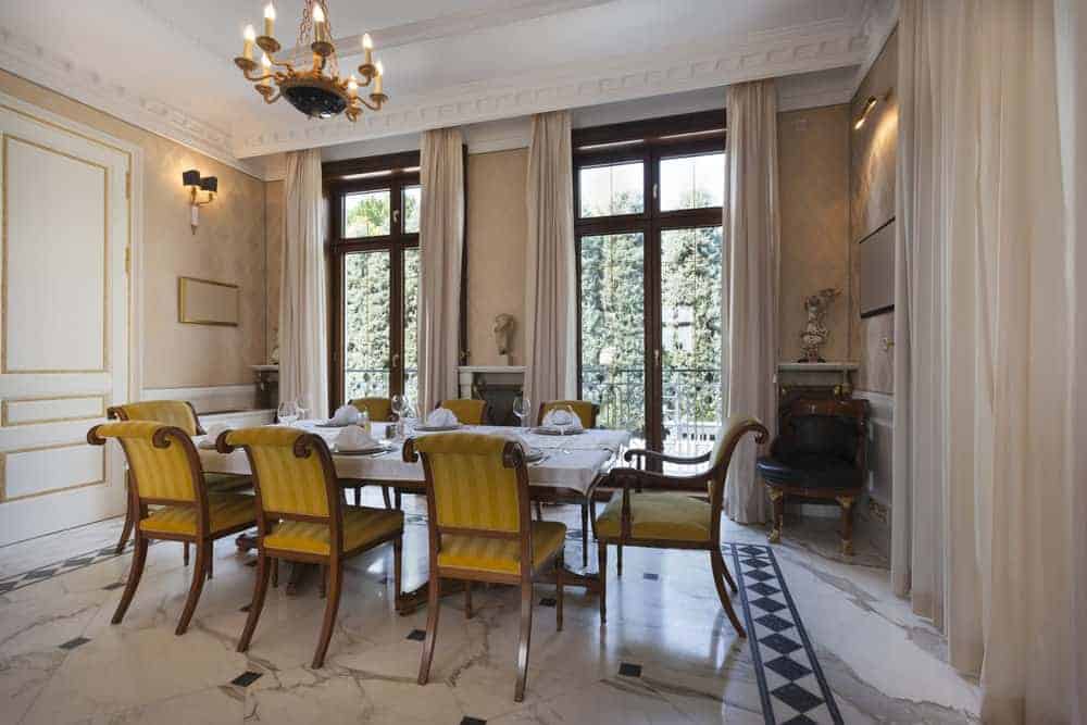 一个大餐厅拥有华丽的天花板和令人惊叹的地板。房间提供了一个优雅的餐桌和椅子设置周围装饰优雅的墙壁。