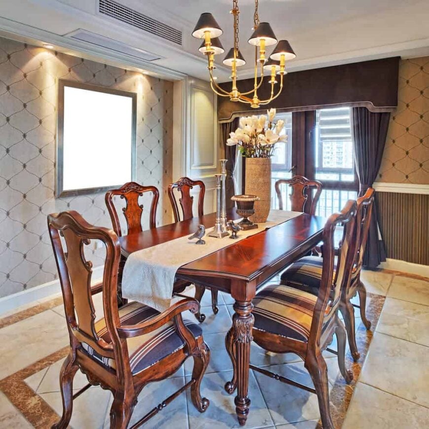 近距离观察这个用餐区华丽的餐桌和椅子，由一个花哨的吊灯照明，周围是装饰优雅的墙壁。
