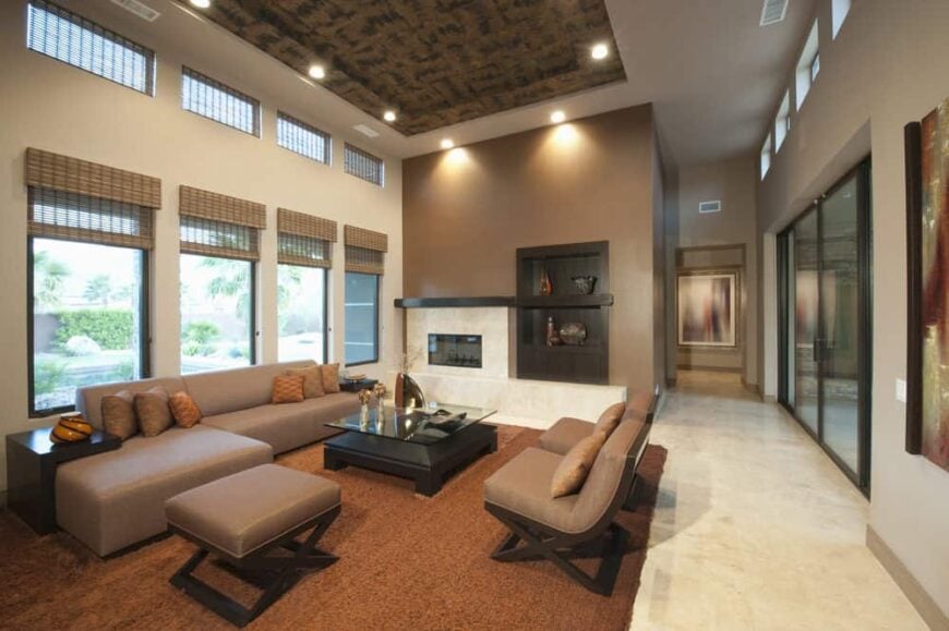 大正式生活空间有一个棕色的沙发套和一个时髦的托盘天花板。房间也提供一个壁炉和一个棕色的小地毯。