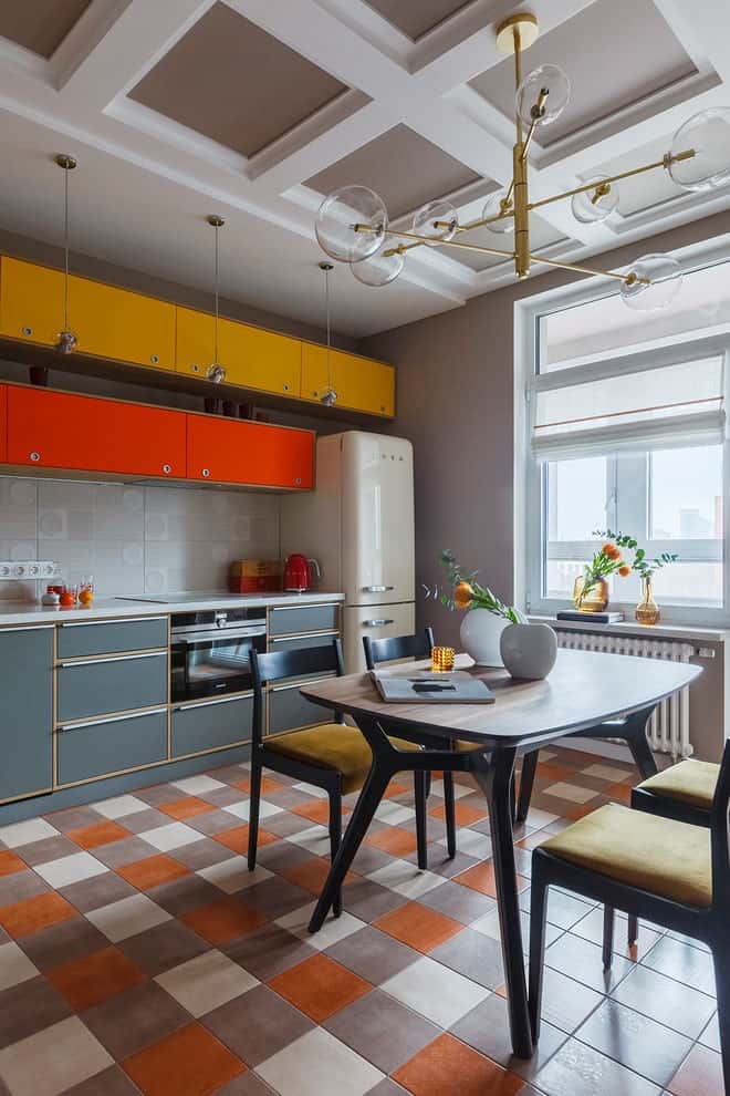 可用餐的厨房里有五颜六色的橱柜，舒适的餐厅由一盏悬挂在格子天花板上的黄铜枝形吊灯照亮。它有格子地板和白色框窗，吸引自然光进入。