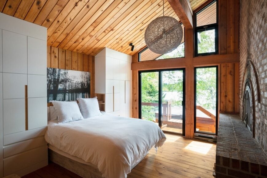 质朴的主卧室设有木棚天花板和硬木地板。床前有一个很大的砖砌壁炉。