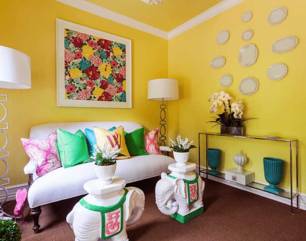 时尚的客厅设计了装饰板和彩色的花卉艺术品，悬挂在白色沙发上，点缀着五颜六色的枕头。