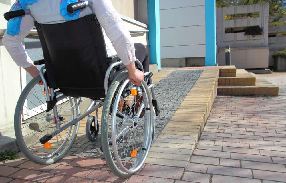 一个坐轮椅的女人上斜坡去一所房子