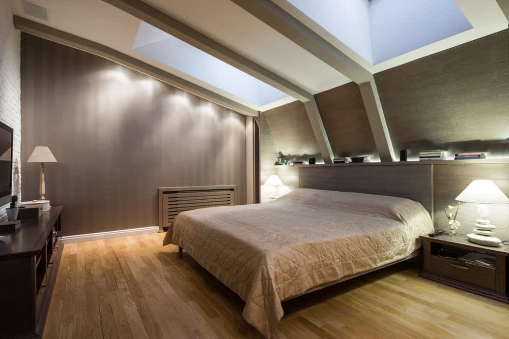 主卧室带带天窗的棚顶。它有棕色的墙壁和硬木地板。它还提供舒适的床和电视机在前面。