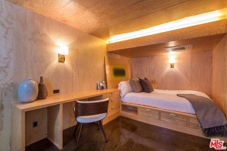 这间主卧有一张漂亮的床和一张书桌。房间的特色是棕色的墙壁和定制的木质天花板。