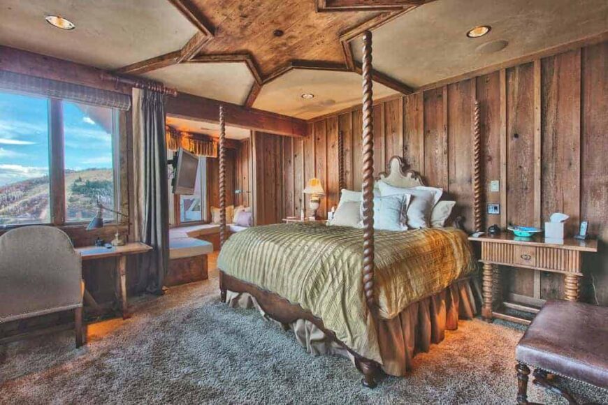 主卧室有令人惊叹的乡村设计天花板和木墙。房间里铺着厚厚的地毯。它配有一张大床、一张靠窗的书桌和角落里的起居空间。
