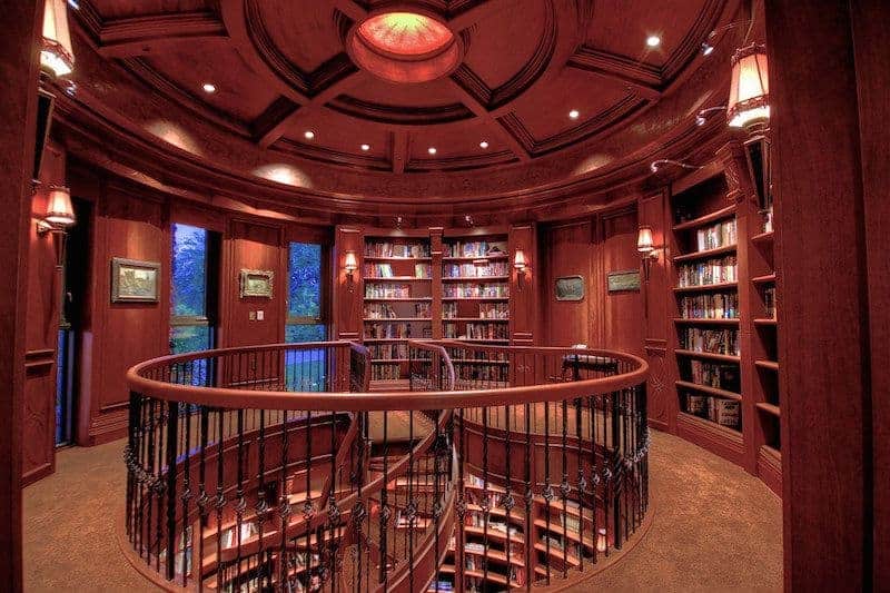 图书馆的圆形形状是优雅的木制天花板，与图书馆的其他部分一样，裸露的红木色调的横梁。这使得书籍以及由壁灯照亮的各种彩色绘画脱颖而出。