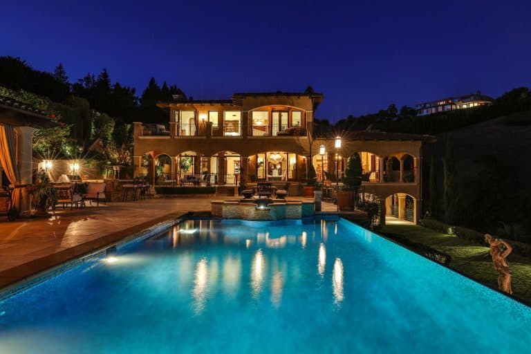 这座豪宅拥有一个休闲的户外区域，地中海风格的游泳池，草坪区和走道。