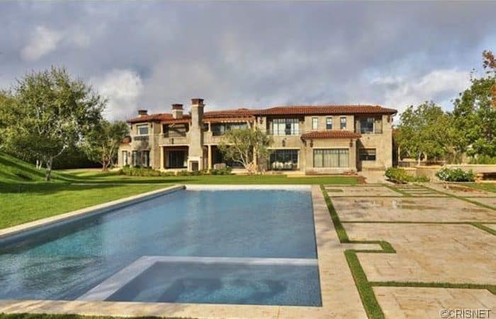豪宅拥有一个大后院，维护良好的草坪区域和一个大的矩形游泳池。