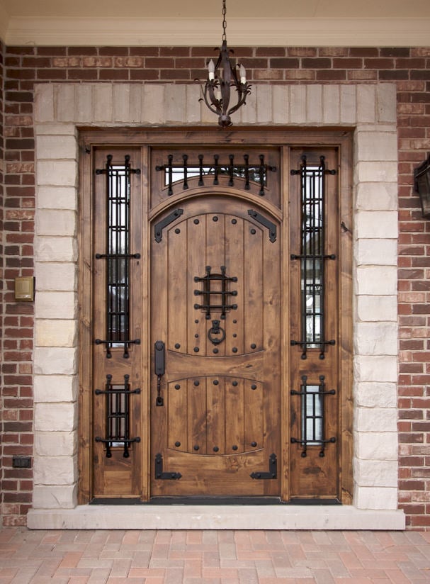 一个经典的木门，让我们想起中世纪的年龄。它配有玻璃插孔和锻铁硬件与复古吊灯配合。