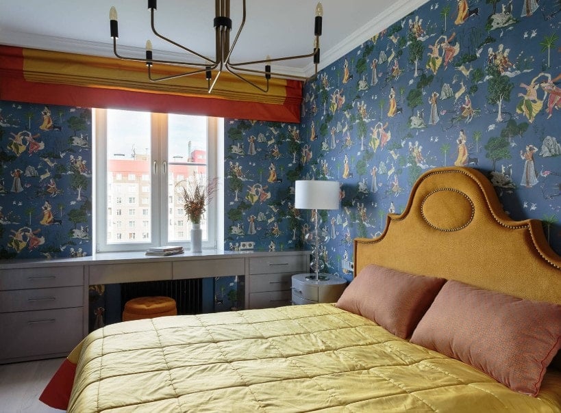小主卧室被蓝色装饰的墙壁包围。房间里有一张带抽屉的嵌壁式书桌，还有一张优雅的大床。