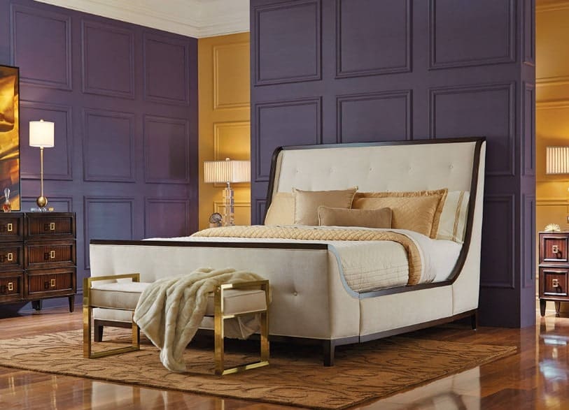 这张照片聚焦在这个主卧室的大床上，还有优雅的金紫色组合墙和闪亮的硬木地板。