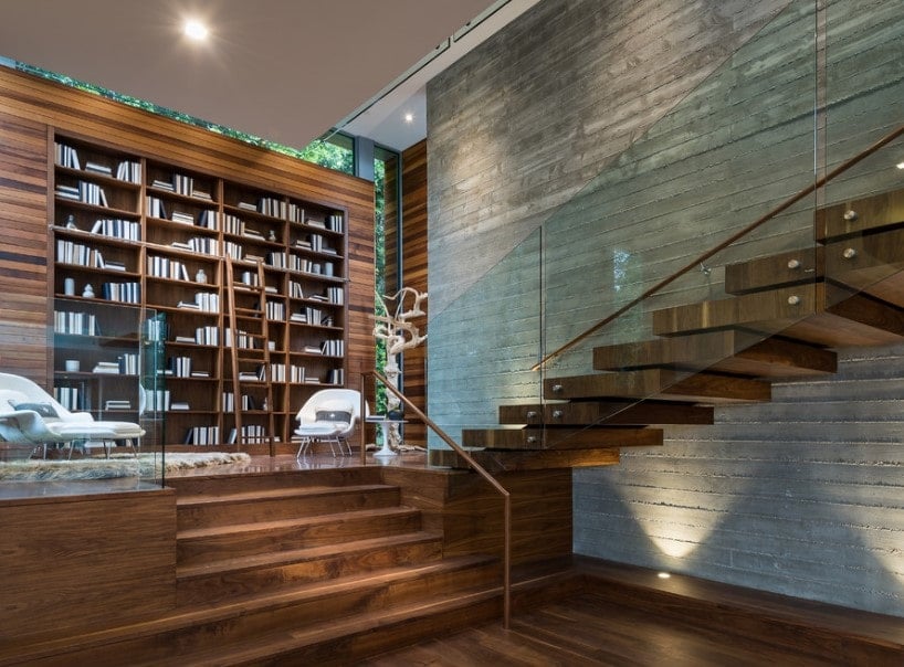 一个令人惊叹的生活空间，设有一个硬木平台，连接到带有硬木台阶和玻璃栏杆的半转弯楼梯。该区域也提供大型书架。
