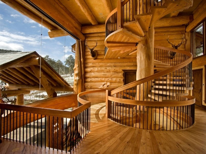 一个大的乡村房子，拥有一个有硬木台阶、硬木扶手和铁栏杆的螺旋楼梯。住宅以原木墙和硬木地板为特色。
