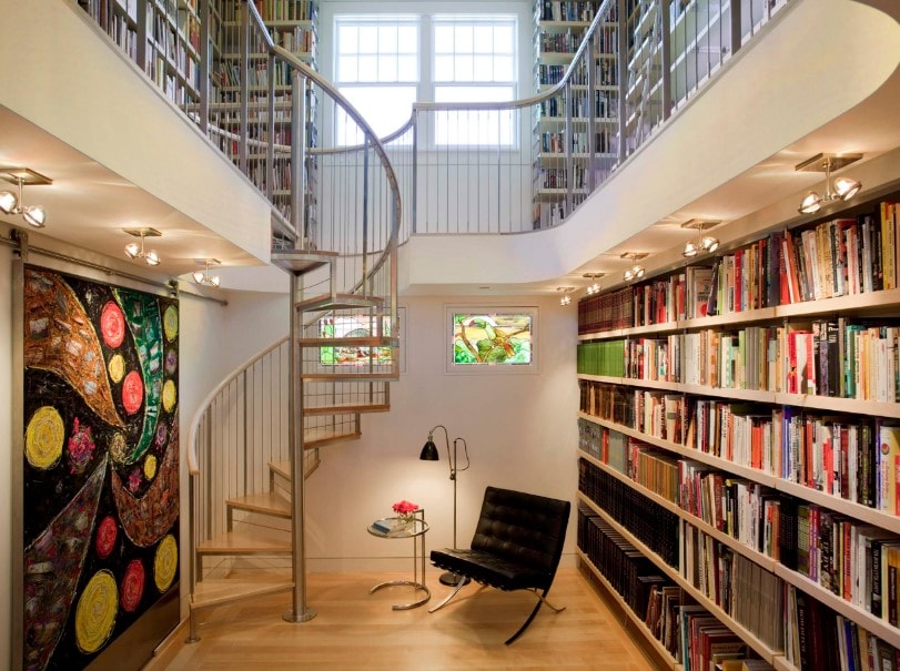图书馆有两层楼高，设有多个书架和通往图书馆二楼的螺旋楼梯。