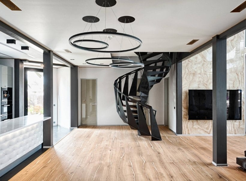 一个当代的房子拥有时尚的天花板和一个令人惊叹的优雅的黑色螺旋楼梯。