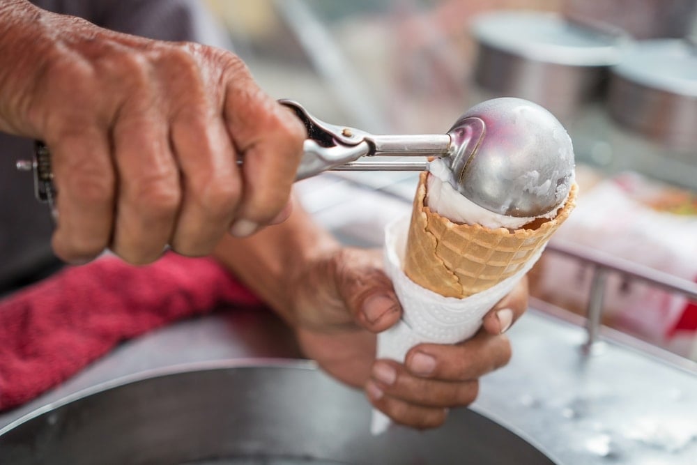冰淇淋勺盖在冰淇淋蛋卷上。