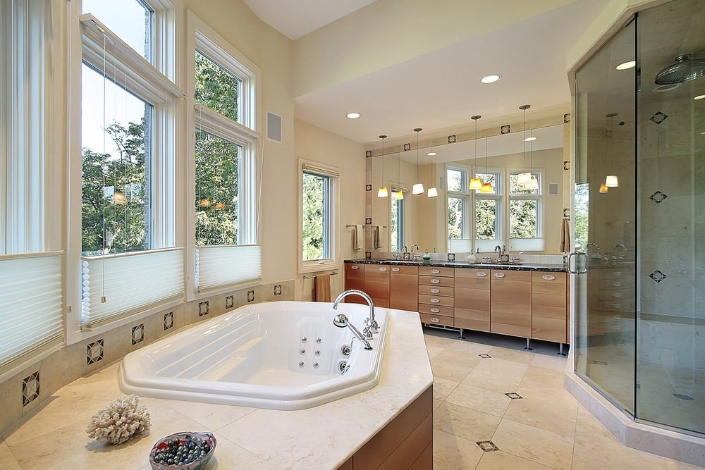 明亮的主浴室设有一个漩涡浴盆和一个由暖吊坠照明的双水槽梳妆台。它包括一个步入式淋浴间和大量的玻璃嵌板窗户，引入充足的自然光线。