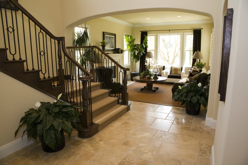 门厅设有四分之一的旋转楼梯，硬木台阶覆盖着地毯。这个入口直接通向家庭的生活空间，配有舒适的沙发和壁炉。