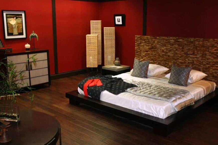 主卧室设有红墙和硬木地板。它有一个令人惊叹的主床设置和优雅的家具件。