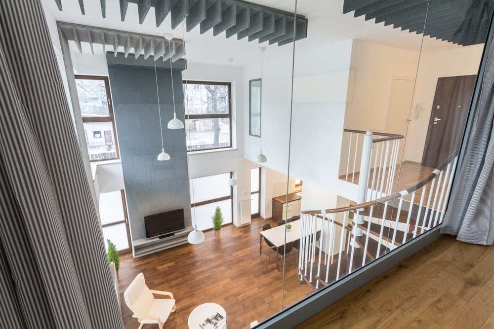 住宅的生活空间以硬木地板和两层天花板为特色，还有白色的墙壁和旋转楼梯。