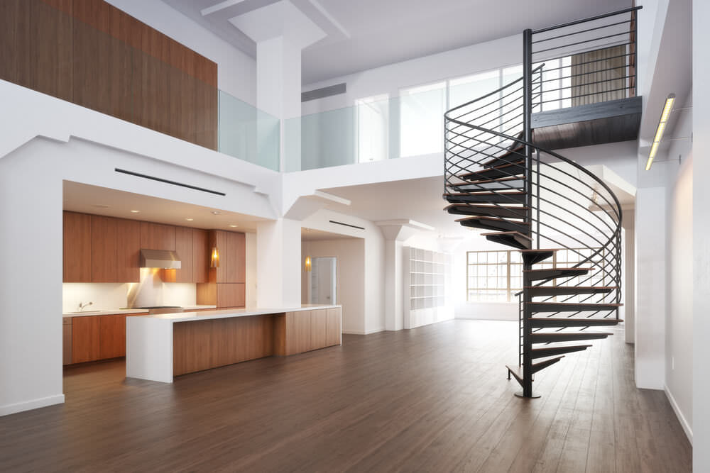 一栋空房子，白色的墙壁和硬木地板，还有两层的天花板。这所房子的特色是一个看起来很时髦的旋转楼梯。