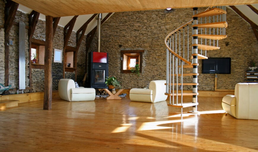 宽敞的起居空间，设有硬木地板，石墙和木质天花板。该区域设有舒适的座椅和带硬木台阶的螺旋楼梯。