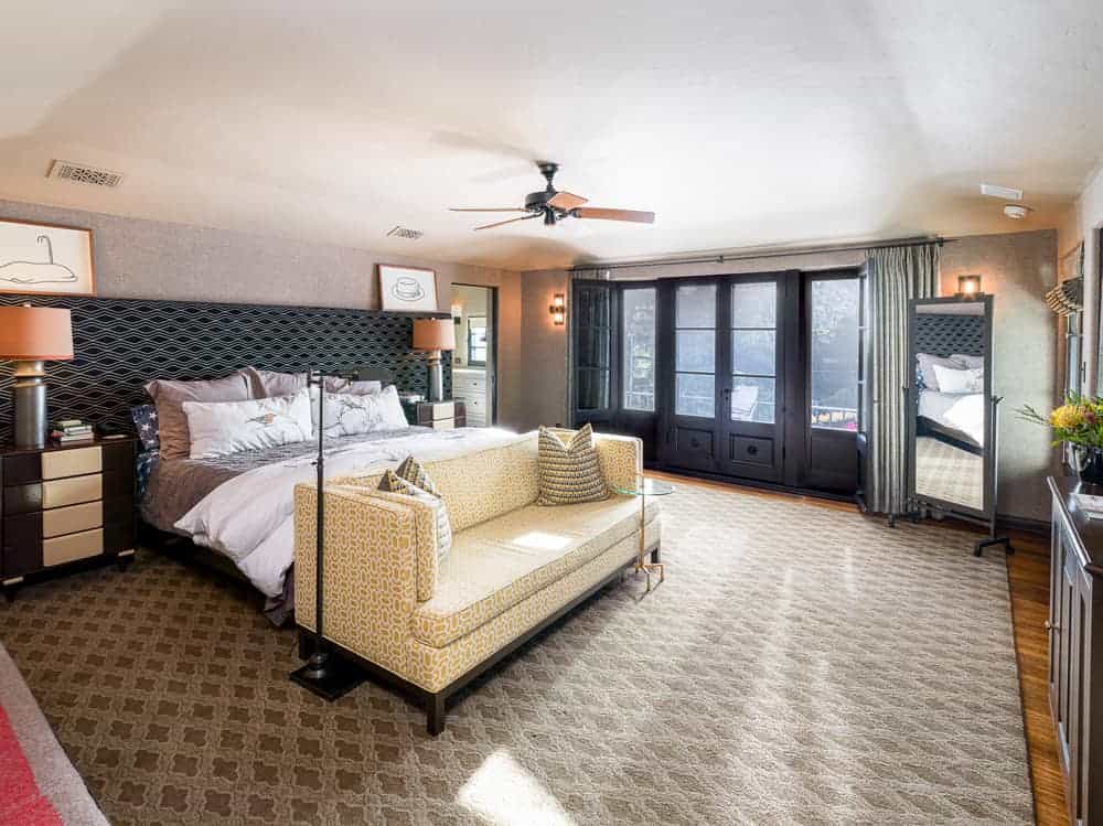 莱昂纳多·迪卡普里奥(Leonardo DiCaprio)曾经拥有的房子里有一间主卧，床脚有一张黄色的印花沙发，配上一张玻璃面边桌，印花地毯上有一盏台灯。