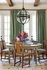绿色的窗帘设置这个迷人的色调和折衷的餐厅设计。我喜欢古董地毯也有一个很好的模式,但不是太浓烈,它扮演的布料。
