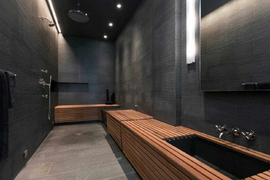 现代主浴室设有黑色墙壁和黑色天花板。它提供时尚的水槽柜台和开放式淋浴。